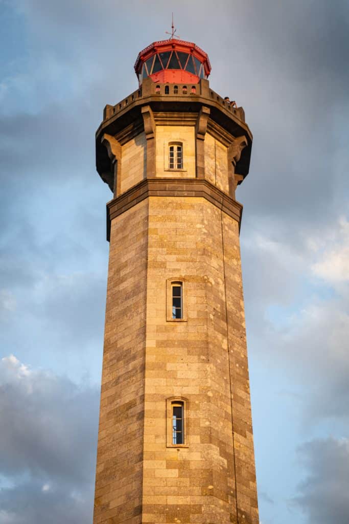 Steinerne Leuchtturm unter bewölktem Himmel.
