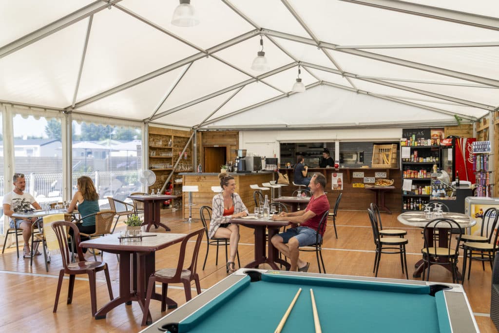 Intérieur d'un café animé avec clients et billard